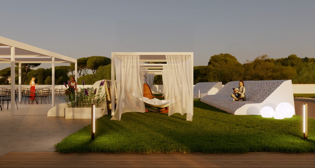 Una terrazza sul tetto con erba verde, moderni lettini con tettoie bianche, una persona seduta su un lettino curvo e tavoli da pranzo all'aperto sullo sfondo al tramonto.